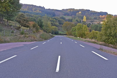 Road amidst trees on landscape