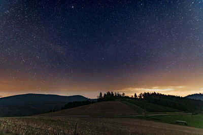 Scenic view of field against sky at night