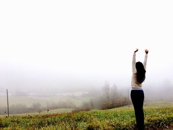 Man standing on field in foggy weather