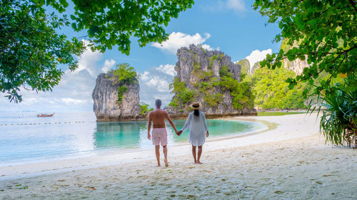 Rear view of woman standing at beach