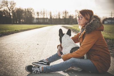 Side view of young woman sitting outdoors