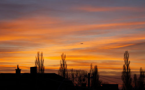 Silhouette buildings against sky during sunset