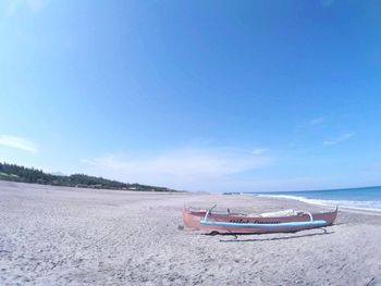 Scenic view of beach against clear blue sky