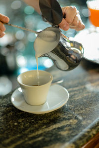 Hands of young adult caucasian female barista at work preparing