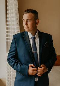 Young man standing against wall