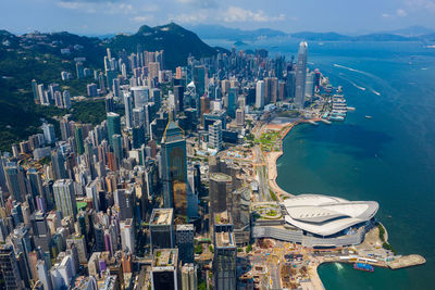 Aerial view of city by sea against sky