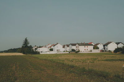 Houses on field against clear sky