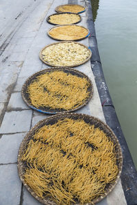 Vertical photo of large round baskets with noodles drying, hoi an, vietnam