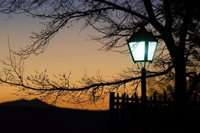 Silhouette of bare tree against sky at sunset