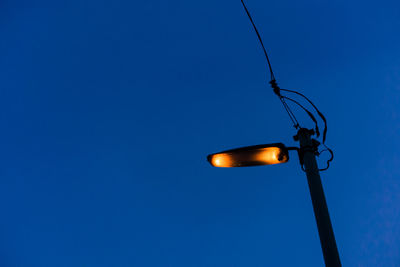 Low angle view of lamp post against clear blue sky