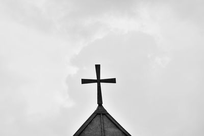 Low angle view of weather vane against sky