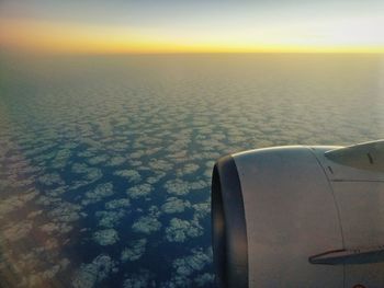 Close-up of airplane wing over sea against sky