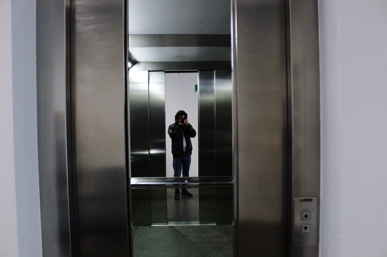 FULL LENGTH OF MAN WALKING IN ILLUMINATED ROOM