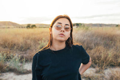 Teenager in sportswear and sunglasses at sunset in the countryside