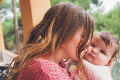 Mother embracing with daughter outdoors