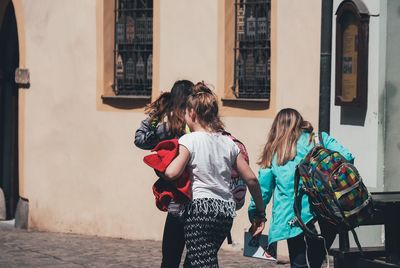 Rear view of women walking in city