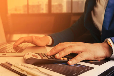 Midsection of man using laptop on table