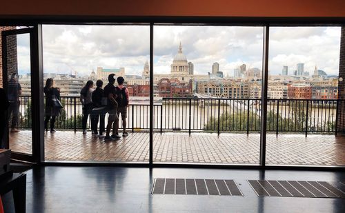 People on glass window in city