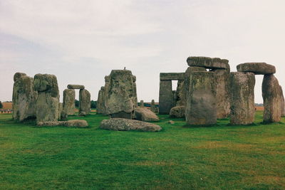 Rock formations on grassy field at stonehenge against clear sky