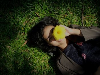 High angle portrait of woman lying on grass