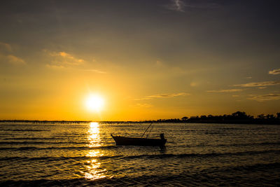 Silhouette boat in sea against sky during sunset