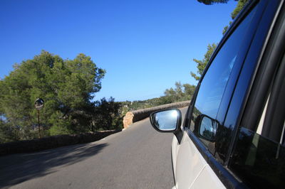 Car on road against clear blue sky