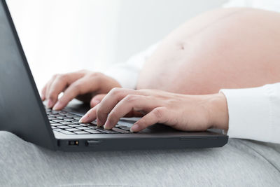 Midsection of man using laptop on table