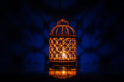 Selective focus of golden lantern with reflection from background for the muslim ramadan kareem.