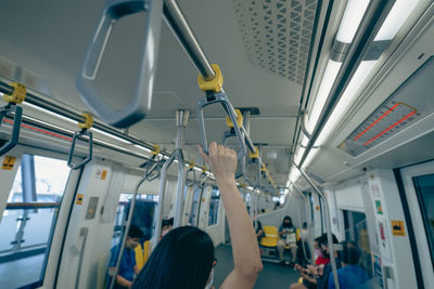 Woman hand firm grip safety handrail in elevated monorail train. mass transit system in modern city.