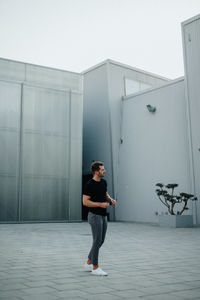 Full length of man standing against building