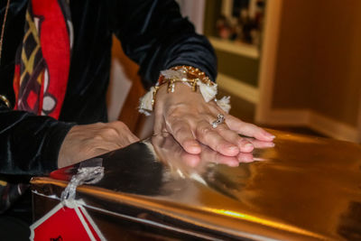 Midsection of woman holding metallic container