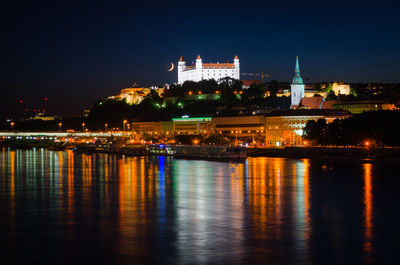 Danube river with illuminated light reflection against bratislava castle at night