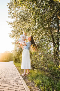 Rear view of woman standing against plants