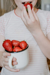 Midsection of woman holding strawberries