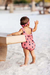 Side view of woman sitting on sand at beach