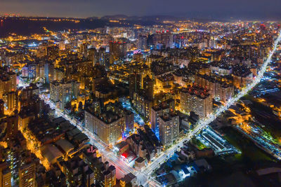 High angle view of city lit up at night
