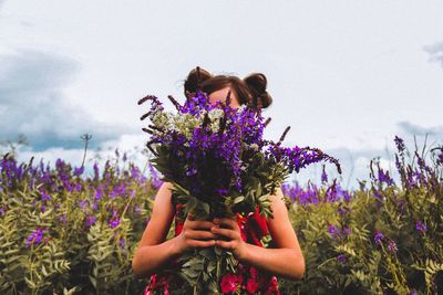 Low angle view of purple flowering plants on field