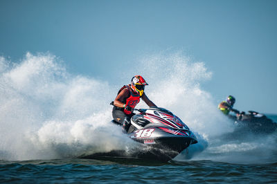 People enjoying in water against sky