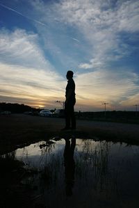 Silhouette of man standing on beach against sky