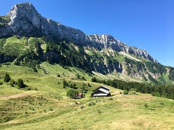 Scenic view of landscape and mountains against clear sky