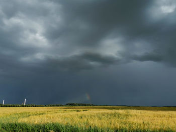 Scenic view of field against cloudy sky