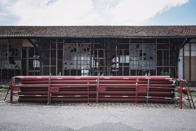 Empty chairs outside house against sky in city