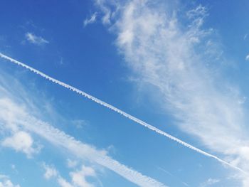 Low angle view of vapor trail in blue sky