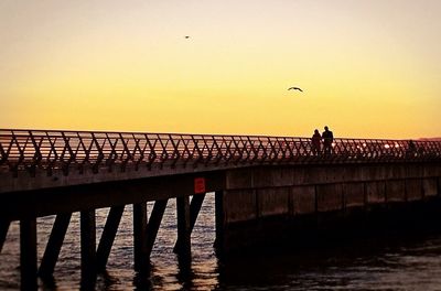 Pier on sea at sunset