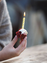 Little boy holding a birthday cake with a lighted candle