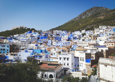 Buildings in town against clear blue sky