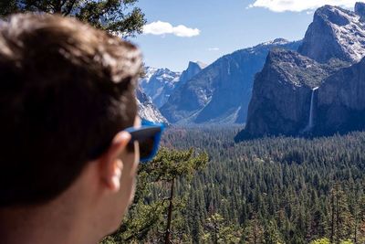 Rear view of man looking at waterfall