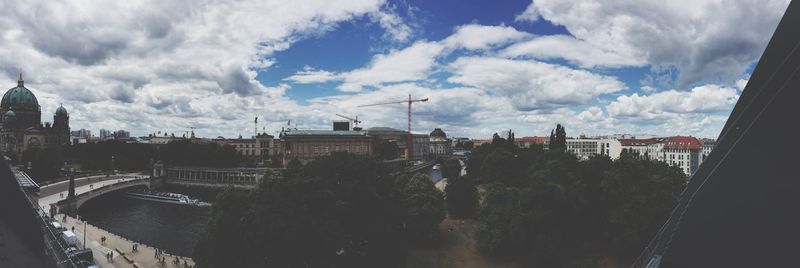 Buildings in city against cloudy sky