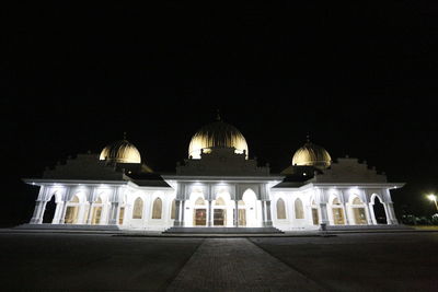 Illuminated building against clear sky at night