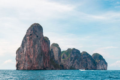 Rock formations by sea against sky